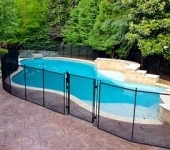 A pool with a fence around it and trees in the background.