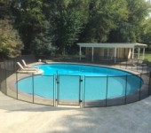 A pool with a fence around it to keep the kids safe.