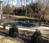 A pool with a fence around it and trees in the background.