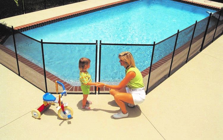 A woman and child by the pool with a fence around them.